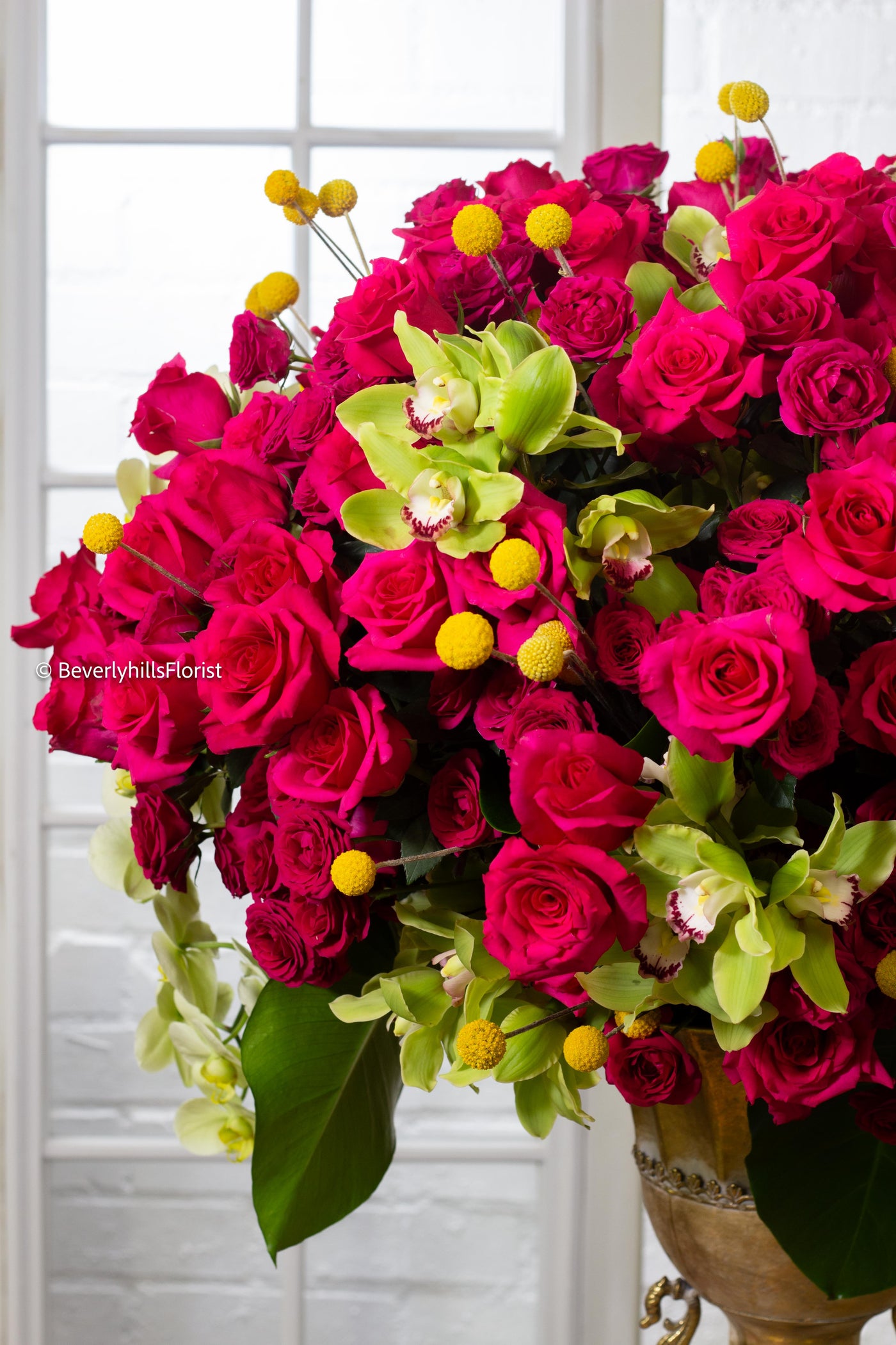 Amore Roses arrangement with red and pink Ecuadorian roses, spray roses, and orchids in a golden pedestal container, 40-inch round, elegant and romantic.