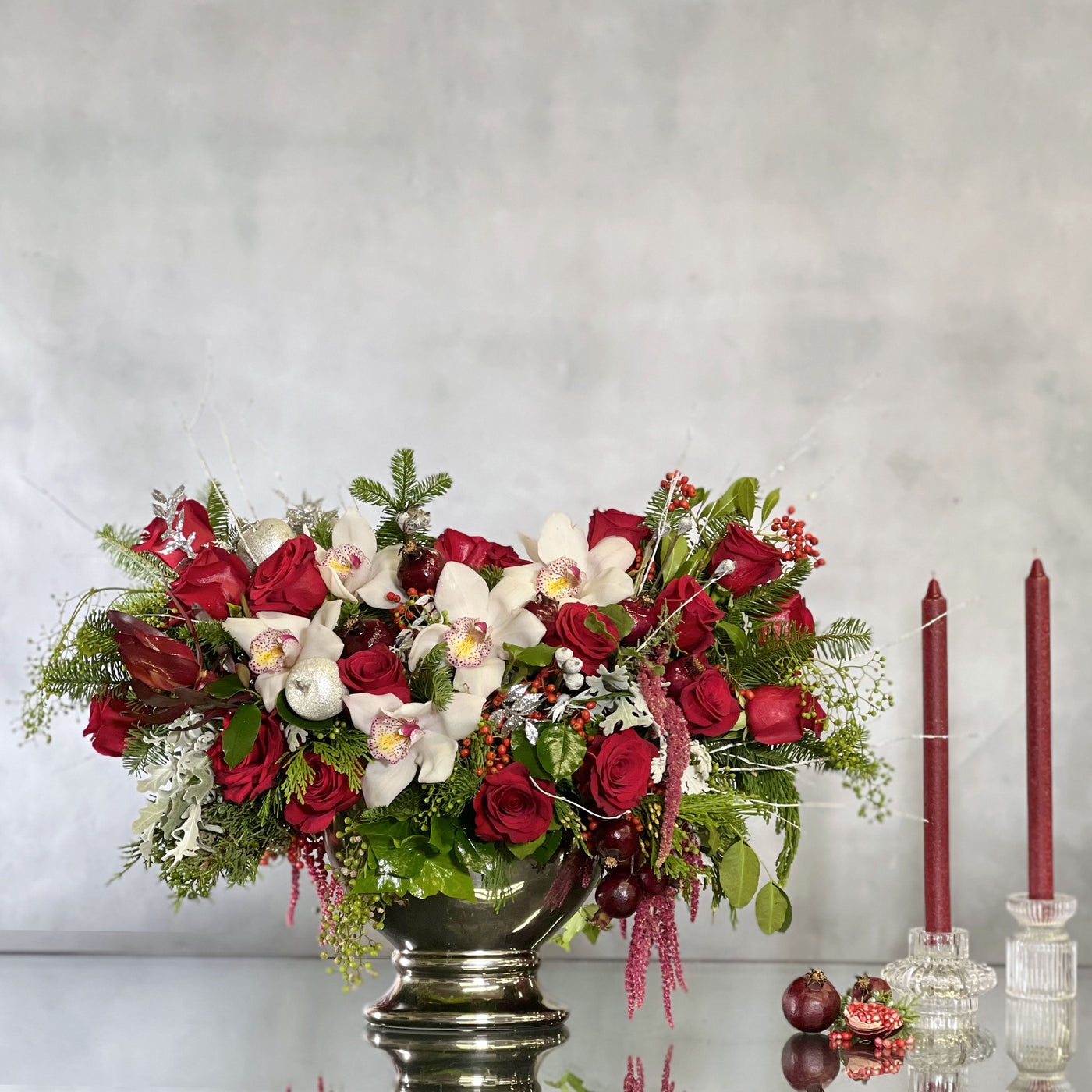 Silver, white, and red Christmas decorations with festive floral arrangements and sparkling ornaments