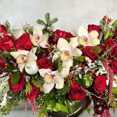 Silver, white, and red Christmas decorations with festive floral arrangements and sparkling ornaments