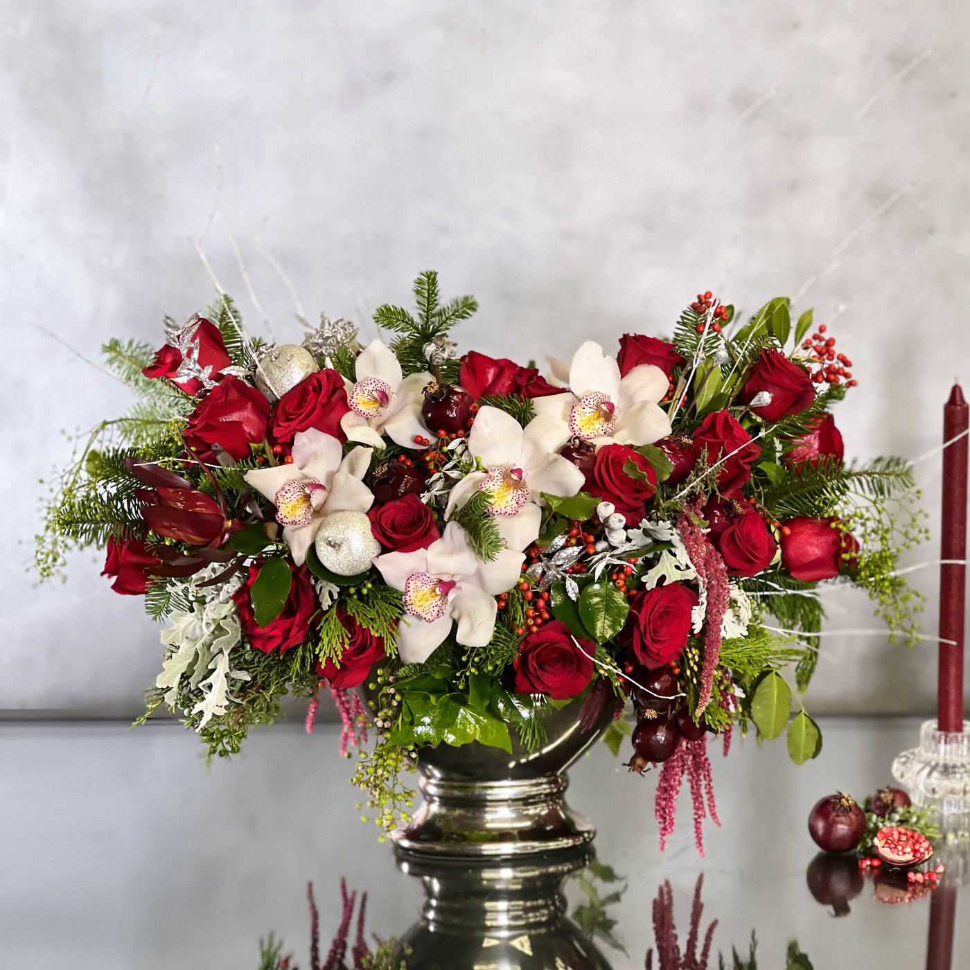 Silver, white, and red Christmas decorations with festive floral arrangements and sparkling ornaments