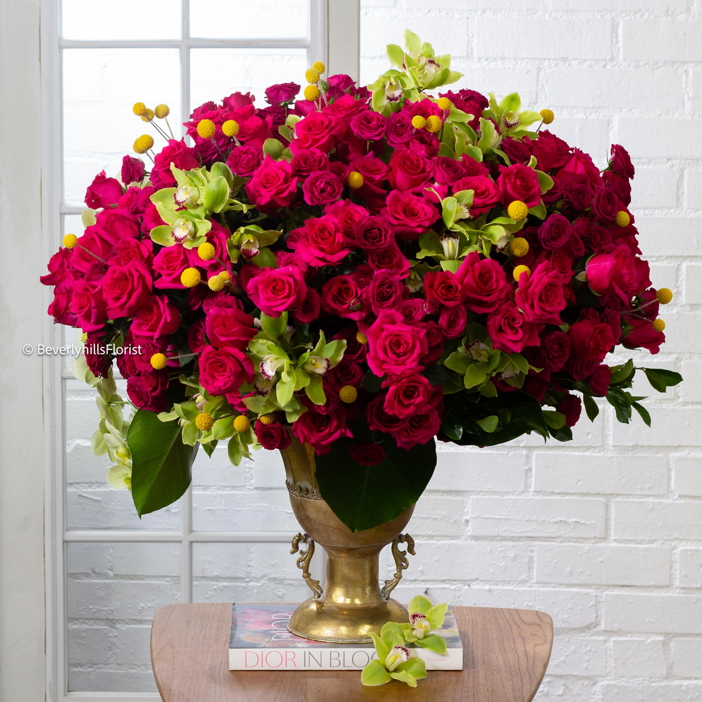 Amore Roses arrangement with red and pink Ecuadorian roses, spray roses, and orchids in a golden pedestal container, 40-inch round, elegant and romantic.