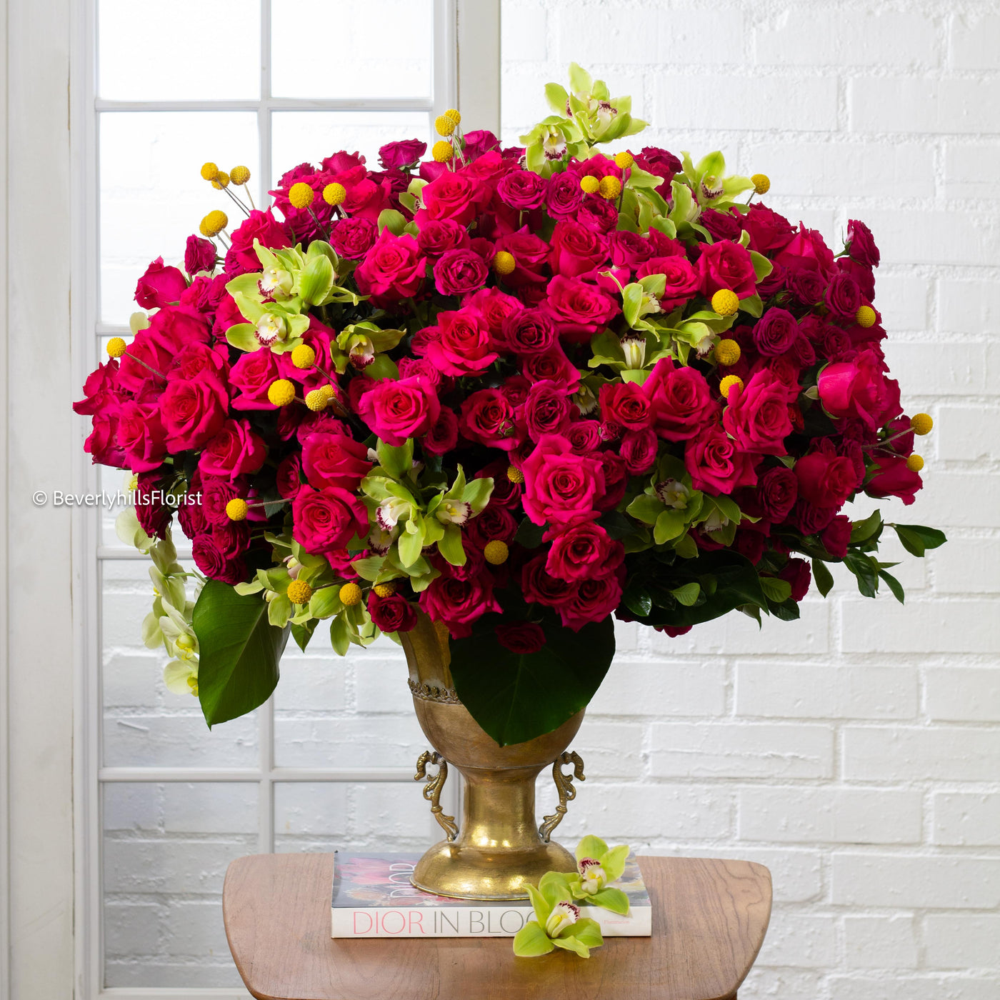 Amore Roses arrangement with red and pink Ecuadorian roses, spray roses, and orchids in a golden pedestal container, 40-inch round, elegant and romantic.