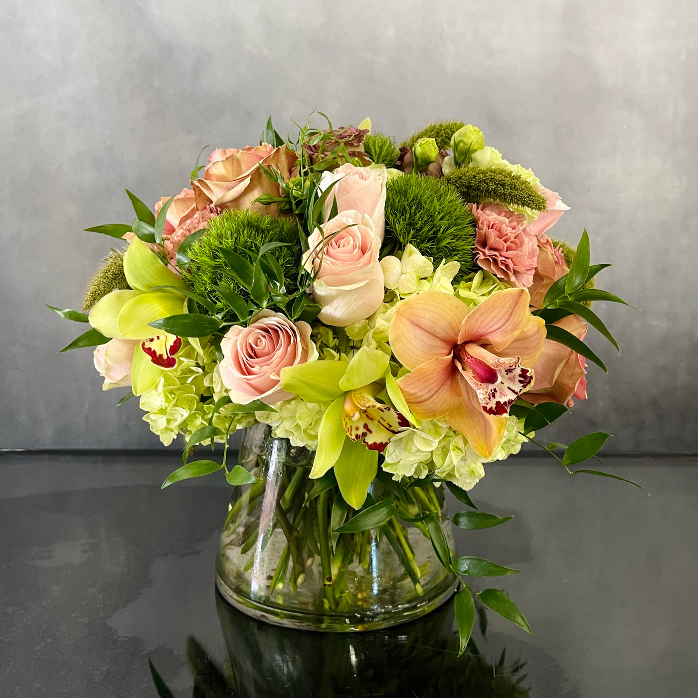 Beautiful Garden arrangement with pink roses, green and peach orchids, hydrangeas, and dianthus in a 6x6 cylinder vase, available for same-day delivery by Beverly Hills Florist.