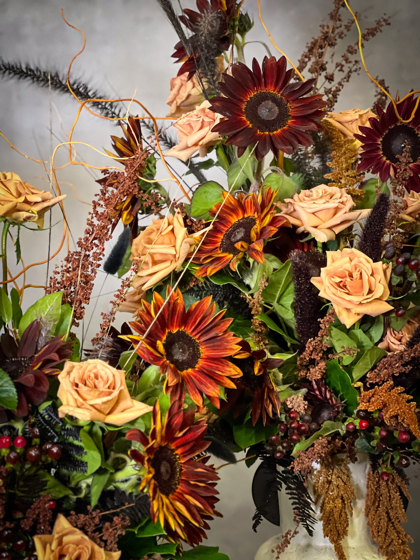 Black Sun arrangement featuring bold sunflowers in a white ceramic vase with black lines, available for same-day delivery by Beverly Hills Florist.