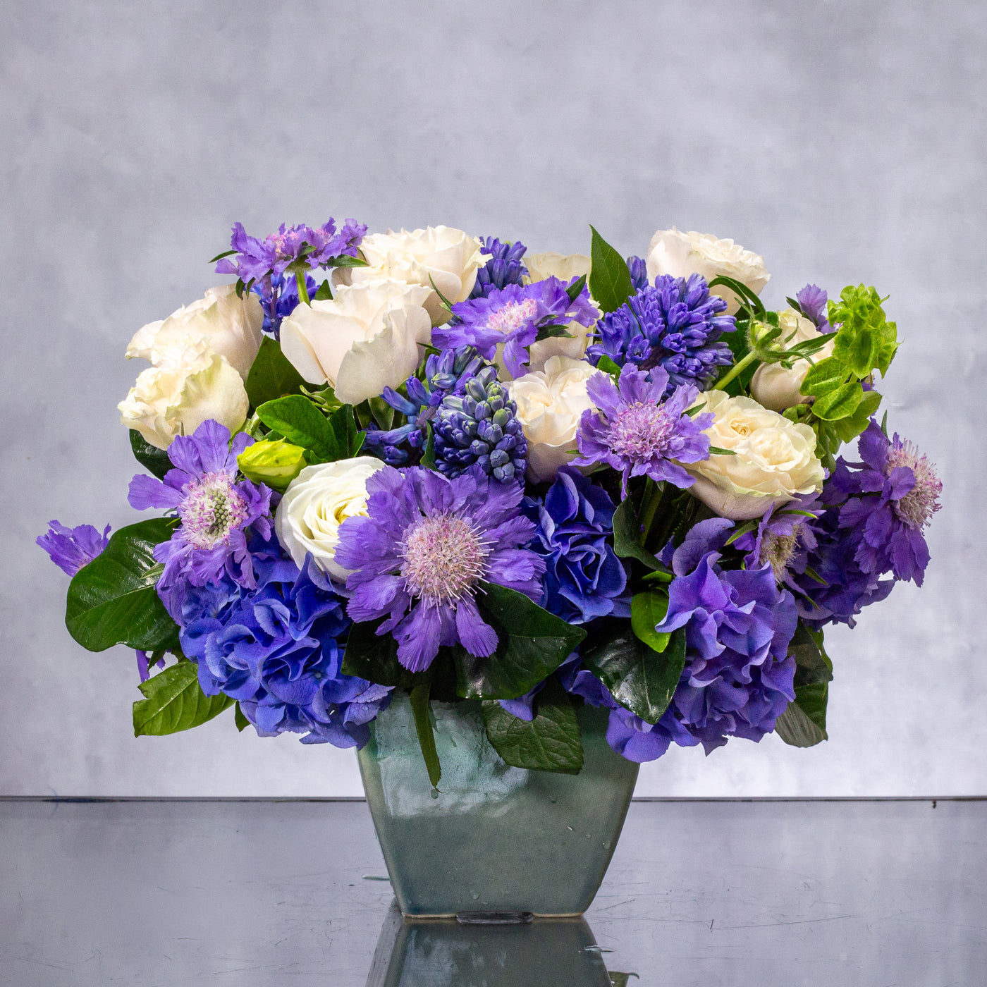 Luxury blue and white flower arrangement with hydrangea, roses, scabiosa, and hyacinths in a ceramic vase – Beverly Hills Florist.