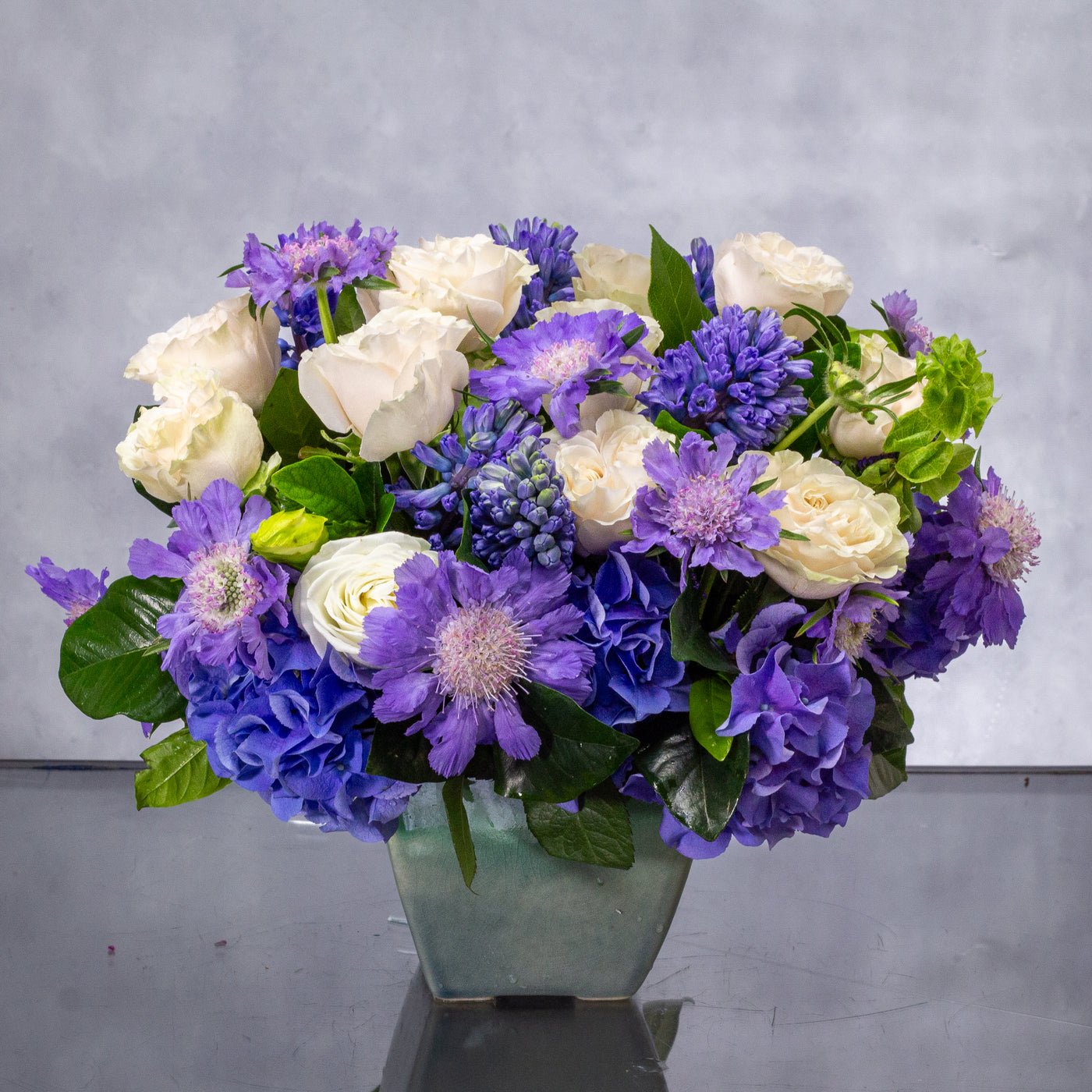 Luxury blue and white flower arrangement with hydrangea, roses, scabiosa, and hyacinths in a ceramic vase – Beverly Hills Florist.