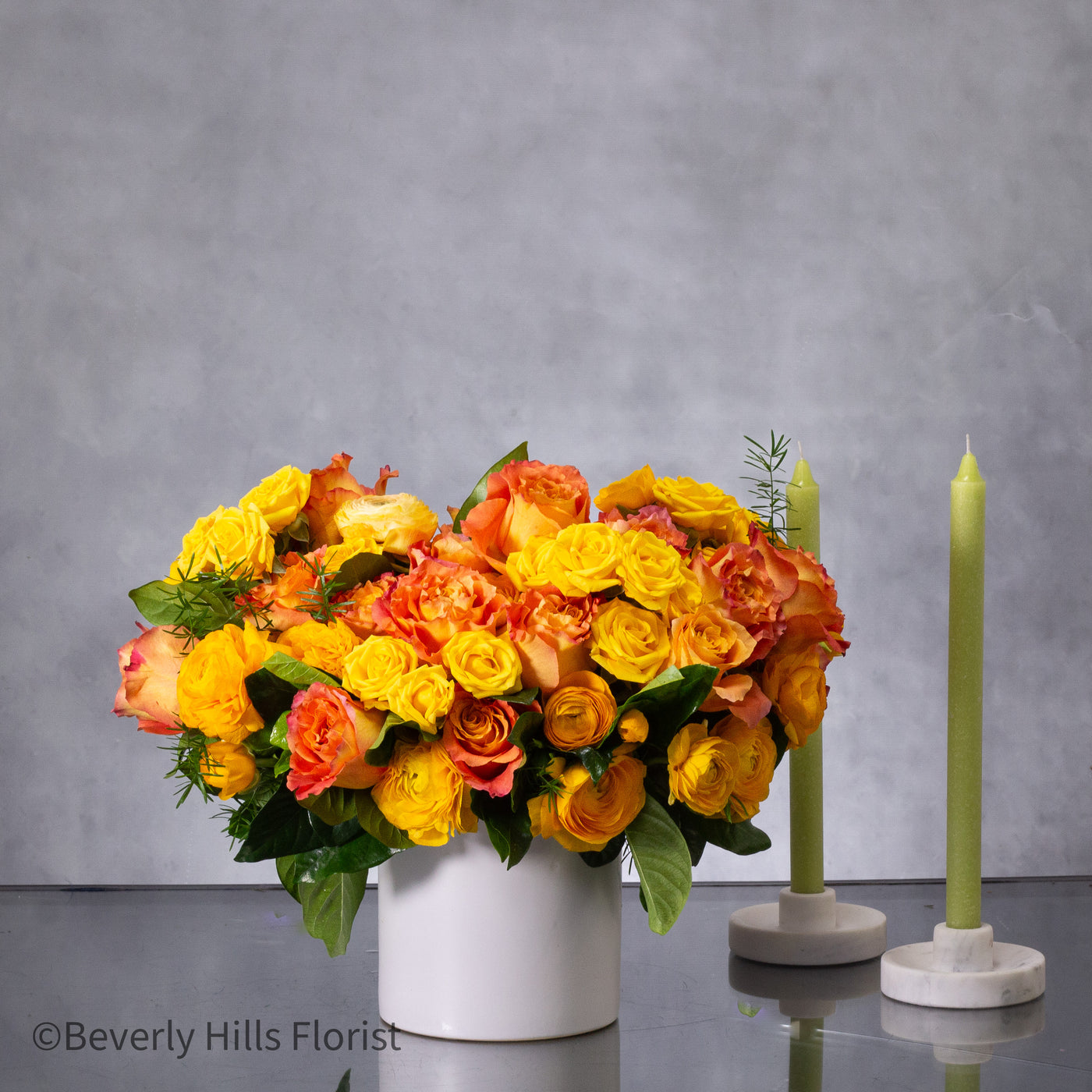 Compact floral arrangement with orange peel-colored blooms in a white ceramic vase, perfect for same-day delivery.