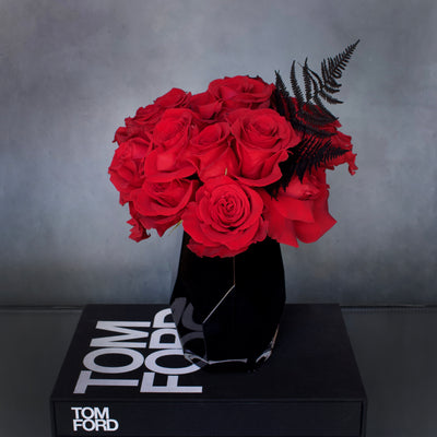 Deep red roses in a black geometric glass vase, measuring 14x9 inches, modern and elegant floral arrangement.