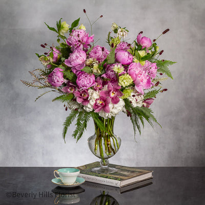 Elegant Floral Fusion arrangement with peonies, cymbidium orchids, and white hydrangeas in a tall glass vase – available for same-day delivery by Beverly Hills Florist.