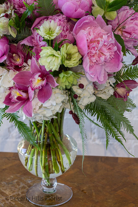 Elegant Floral Fusion arrangement with peonies, cymbidium orchids, and white hydrangeas in a tall glass vase – available for same-day delivery by Beverly Hills Florist.