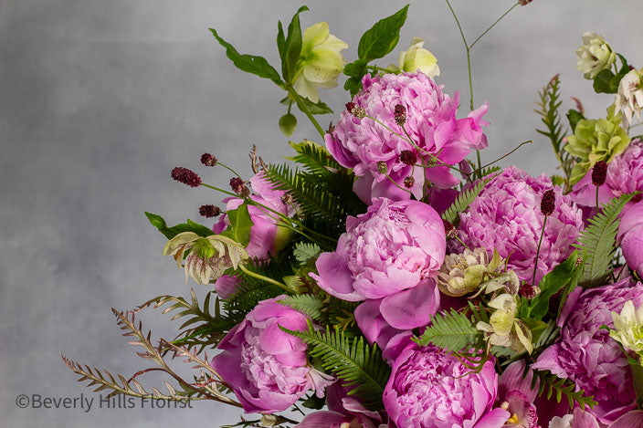 Elegant Floral Fusion arrangement with peonies, cymbidium orchids, and white hydrangeas in a tall glass vase – available for same-day delivery by Beverly Hills Florist.