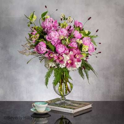 Elegant Floral Fusion arrangement with peonies, cymbidium orchids, and white hydrangeas in a tall glass vase – available for same-day delivery by Beverly Hills Florist.