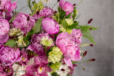 Elegant Floral Fusion arrangement with peonies, cymbidium orchids, and white hydrangeas in a tall glass vase – available for same-day delivery by Beverly Hills Florist.