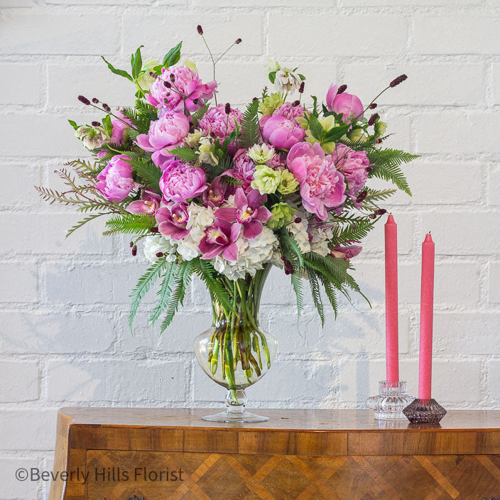 Elegant Floral Fusion arrangement with peonies, cymbidium orchids, and white hydrangeas in a tall glass vase – available for same-day delivery by Beverly Hills Florist.