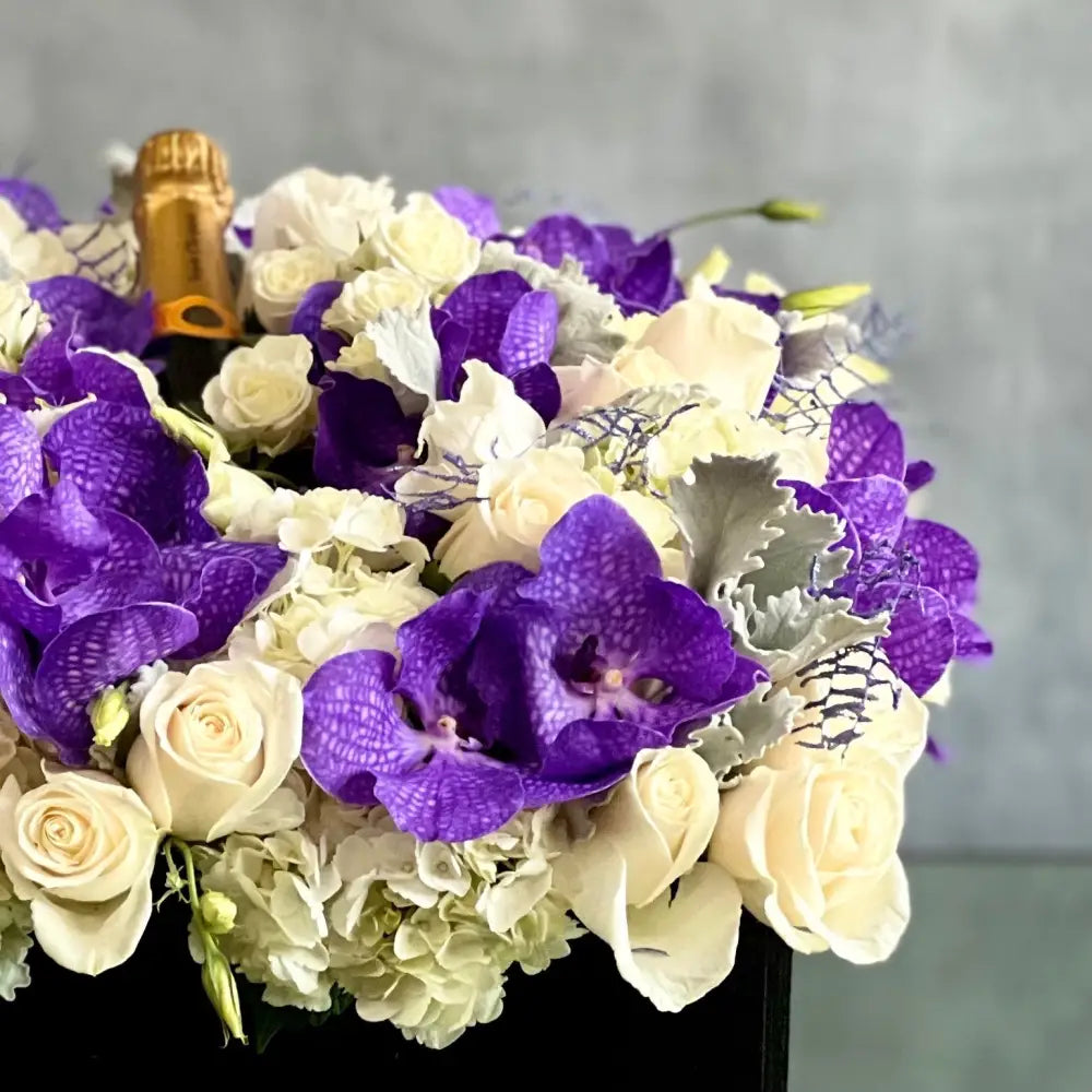 Luxury square flower box with white roses, purple and white Vanda orchids, and Veuve Clicquot champagne by Beverly Hills Florist