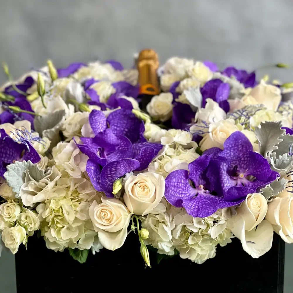 Luxury square flower box with white roses, purple and white Vanda orchids, and Veuve Clicquot champagne by Beverly Hills Florist
