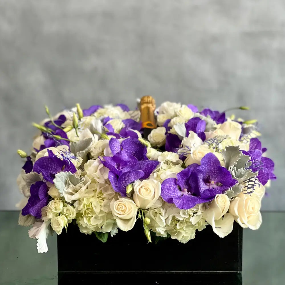 Luxury square flower box with white roses, purple and white Vanda orchids, and Veuve Clicquot champagne by Beverly Hills Florist