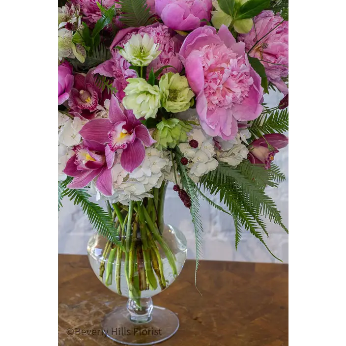 Elegant Floral Fusion arrangement with peonies, cymbidium orchids, and white hydrangeas in a tall glass vase – available for same-day delivery by Beverly Hills Florist.