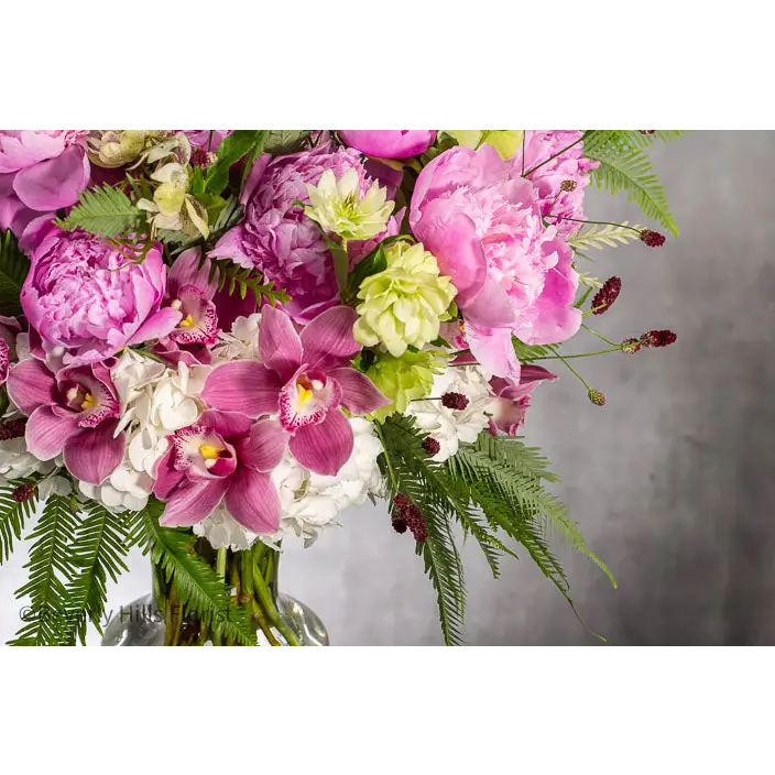 Elegant Floral Fusion arrangement with peonies, cymbidium orchids, and white hydrangeas in a tall glass vase – available for same-day delivery by Beverly Hills Florist.