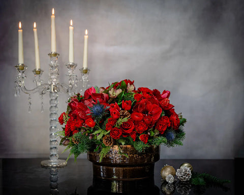 Round Christmas Gift Box with roses, amaryllis, thistle, tulips, orchids, seasonal greens, berries, pine cones, and champagne, available for same-day delivery in Los Angeles.