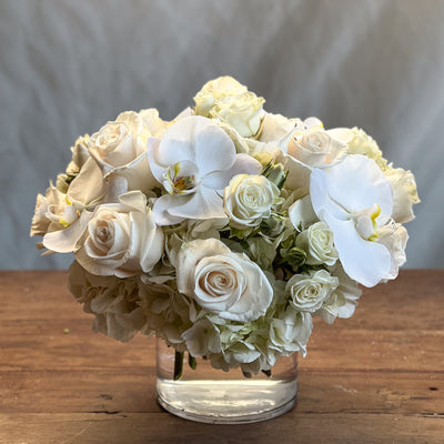 Elegant white roses and orchids arrangement in a glass vase, Beverly Hills Florist.