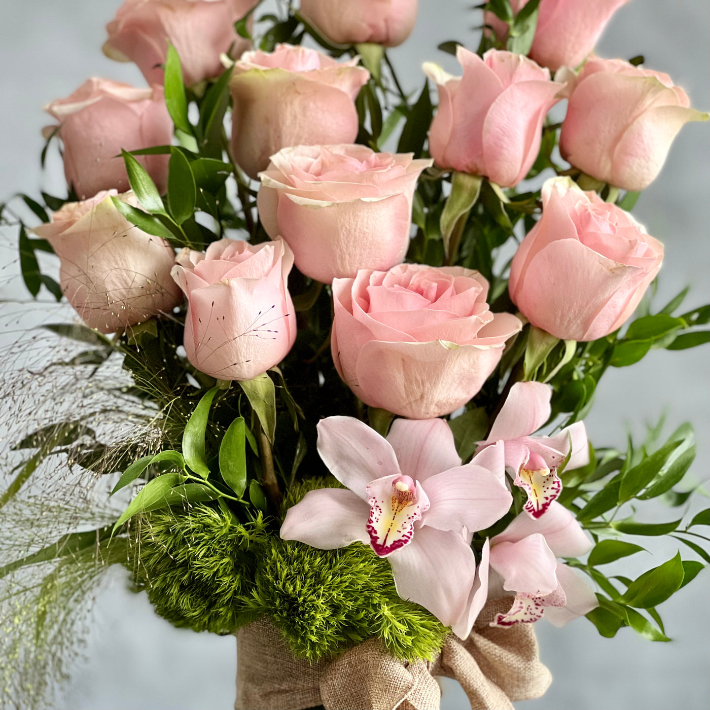 12 Pink Long Stem Roses Standing Tall arrangement with Ecuadorian long-stem roses and cymbidium orchids in a glass vase, available for same-day delivery by Beverly Hills Florist.