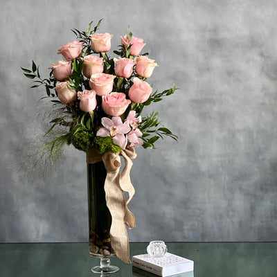 12 Pink Long Stem Roses Standing Tall arrangement with Ecuadorian long-stem roses and cymbidium orchids in a glass vase, available for same-day delivery by Beverly Hills Florist.