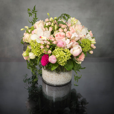 Same day delivery at Beverly Hills Florist ! Breathtaking medley of beautiful pink Ecuadorian roses and spray roses, peonies, cymbidium orchids, lime green accents and other seasonal floral that are artistically arranged to create this stunning design in a white rocks glass vase. The pink-white lime is a delightful combination to express happiness!