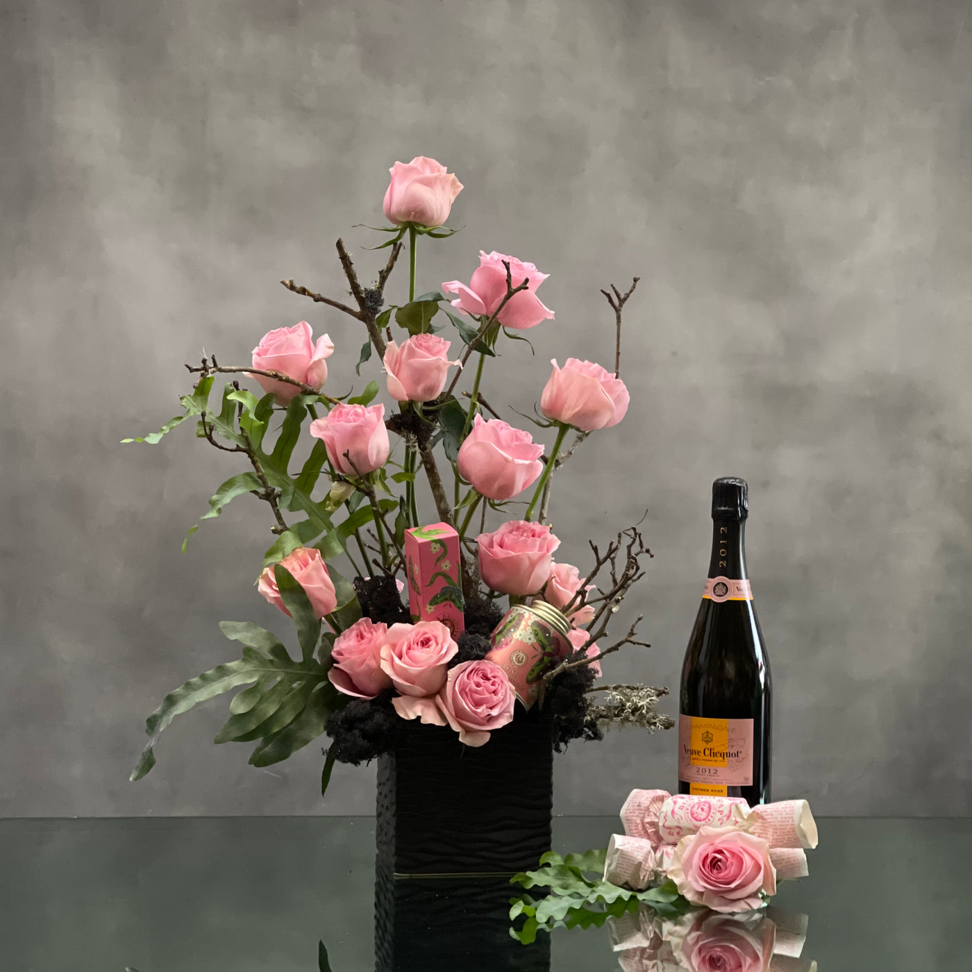 Beverly Hills Florist presents 2 dozen pink roses accented with greenery and branch in a black ceramic vase for same day delivery. Our product includes, Veuve Clicquot, bath salts, hand lotion and bath soap. A thoughtful love and romance gift, thank you gift and perfect for a nice celebration ! 