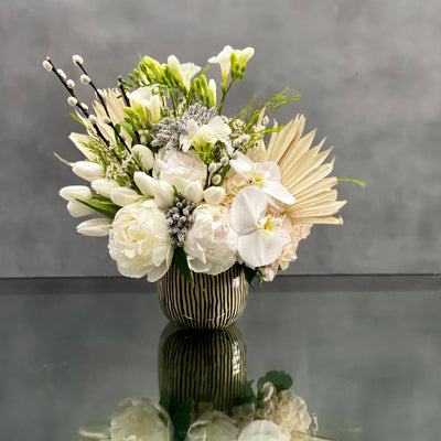 This arrangement is made with a designer's choice array of seasonal white flowers. Floral could include Roses, Hydrangeas, Orchids, Tulips and or Peonies. These beautiful white flowers are an excellent choice for weddings, funerals and other major life events. Our team at Beverly Hills Florist offers same day delivery! 