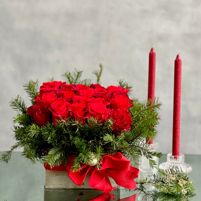 A Merry Little Christmas centerpiece with red roses, greenery, and gold ornaments, available for same-day delivery by Beverly Hills Florist.