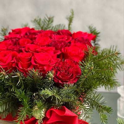 A Merry Little Christmas centerpiece with red roses, greenery, and gold ornaments, available for same-day delivery by Beverly Hills Florist.