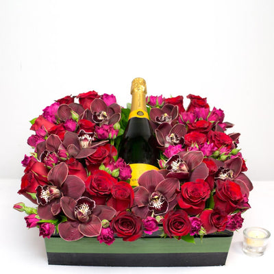 A Toast To You! arrangement with red and pink roses, burgundy orchids, and a bottle of wine in a square box, same-day delivery by Beverly Hills Florist.