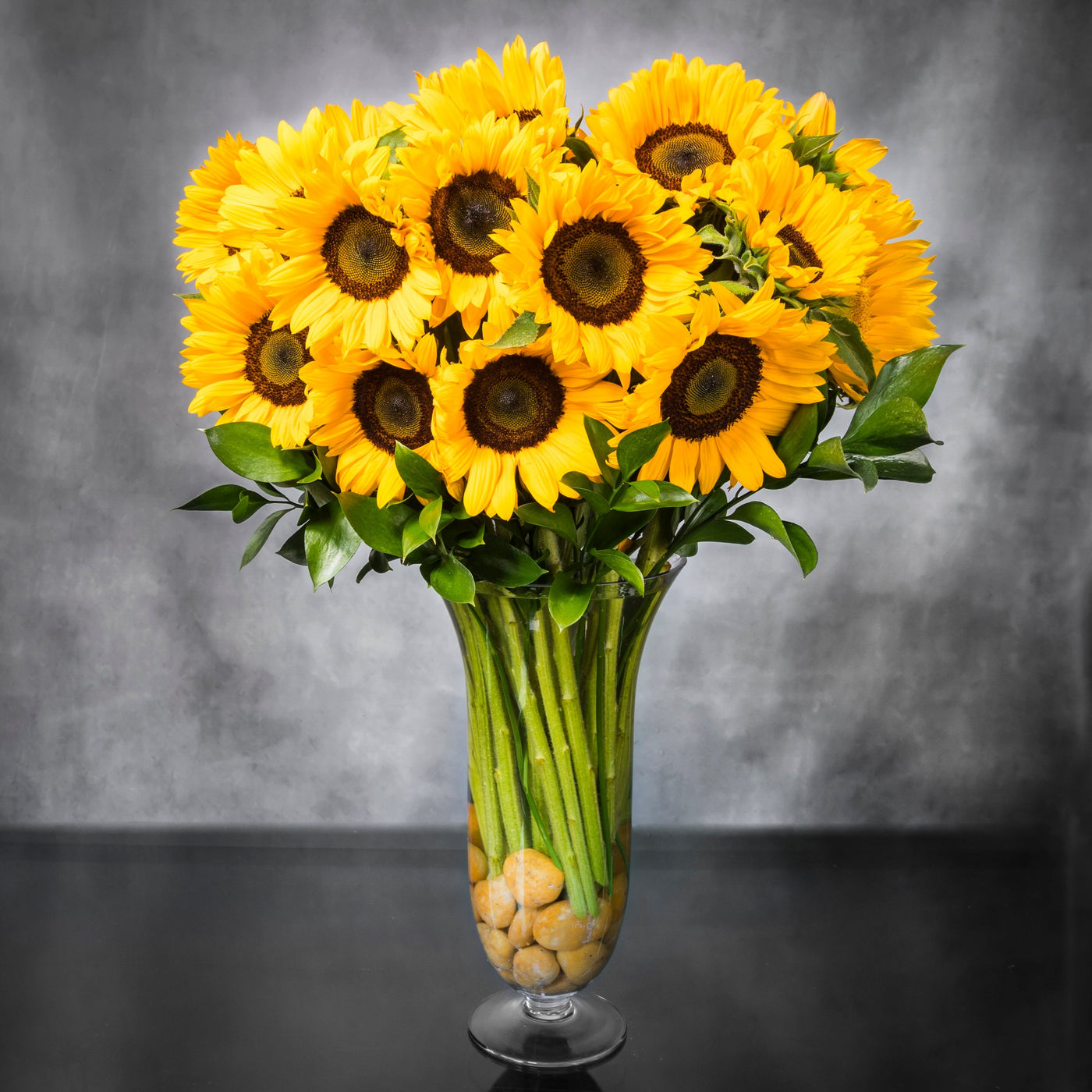 Baby It's Sunny Outside arrangement with tall sunflowers in a vase with pebbles, available for same-day delivery by Beverly Hills Florist.