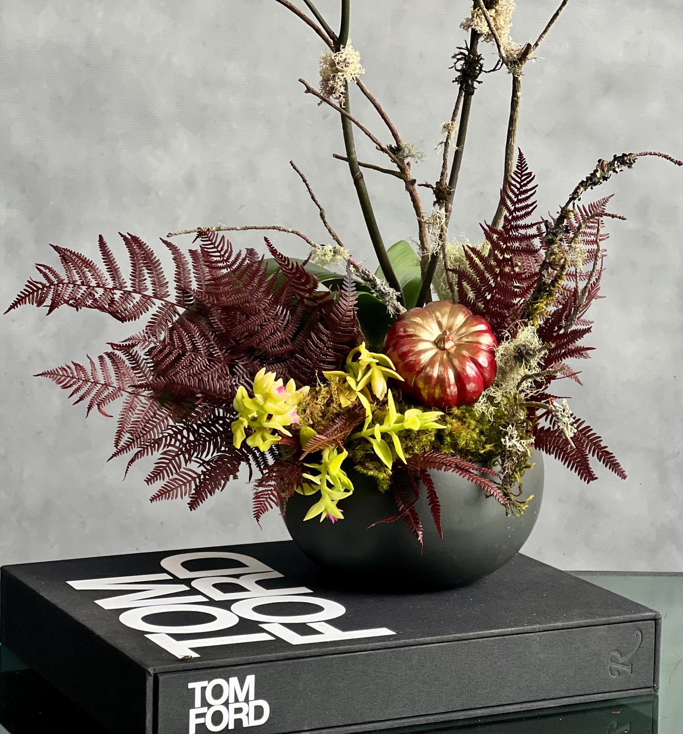 Beautiful as Always double yellow orchids with fall accents in a modern matte black ceramic bowl, available for same-day delivery by Beverly Hills Florist.