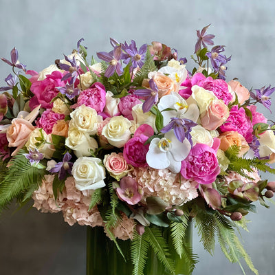 Blooming arrangement with peonies, roses, orchids, hydrangeas, and seasonal greens in a chic design, available for same-day delivery by Beverly Hills Florist.