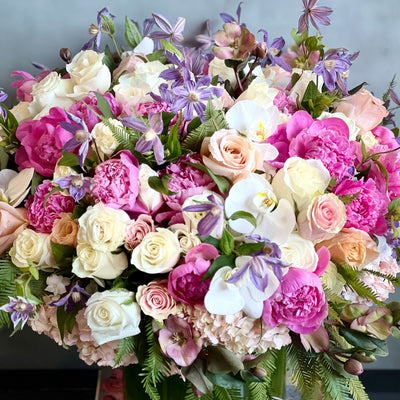 Blooming arrangement with peonies, roses, orchids, hydrangeas, and seasonal greens in a chic design, available for same-day delivery by Beverly Hills Florist.