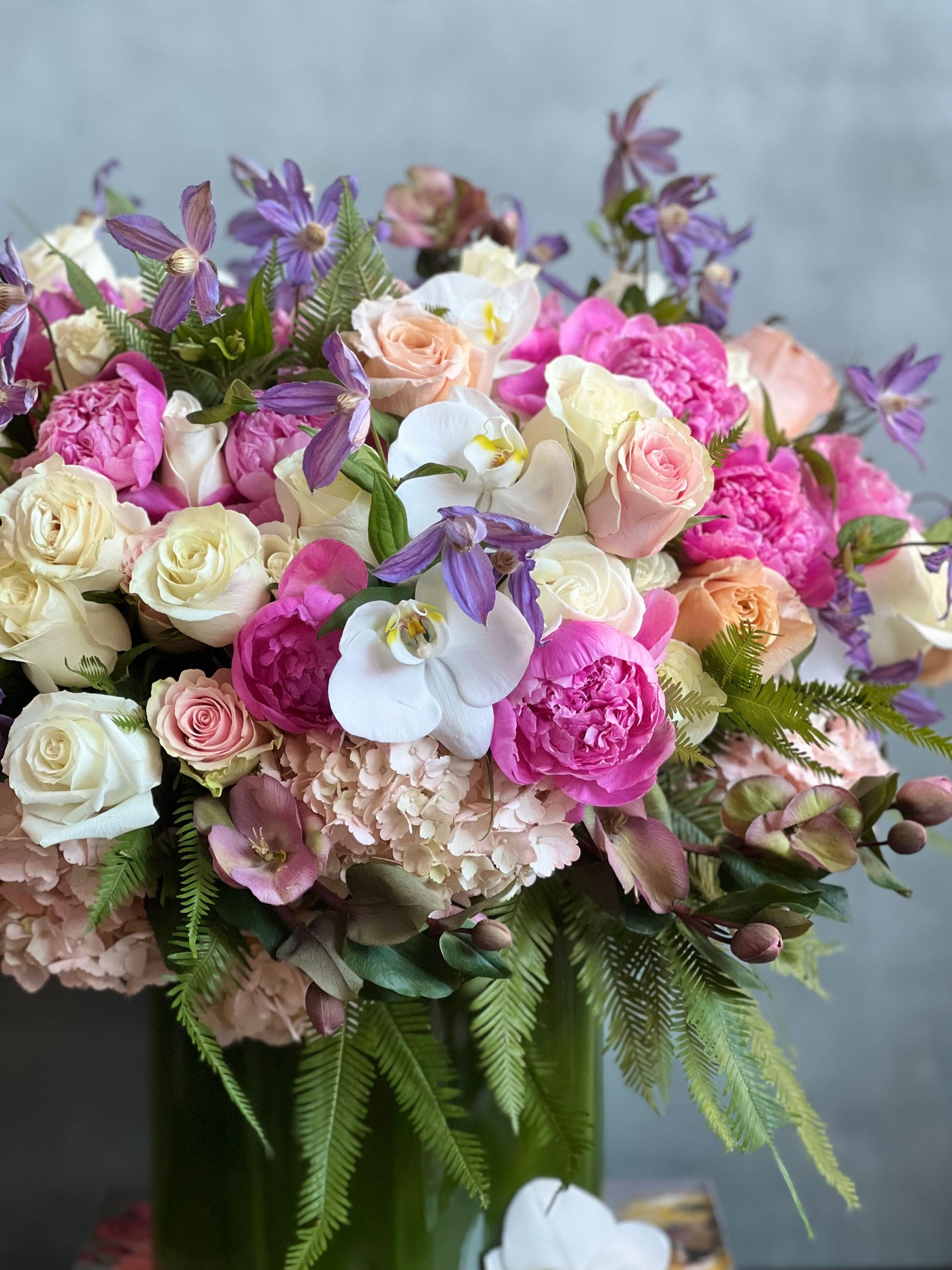 Blooming arrangement with peonies, roses, orchids, hydrangeas, and seasonal greens in a chic design, available for same-day delivery by Beverly Hills Florist.