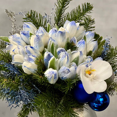 Blue Holiday arrangement with snow-tinted tulips and an orchid in a glass vase, available for same-day delivery by Beverly Hills Florist.