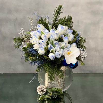 Blue Holiday arrangement with snow-tinted tulips and an orchid in a glass vase, available for same-day delivery by Beverly Hills Florist.