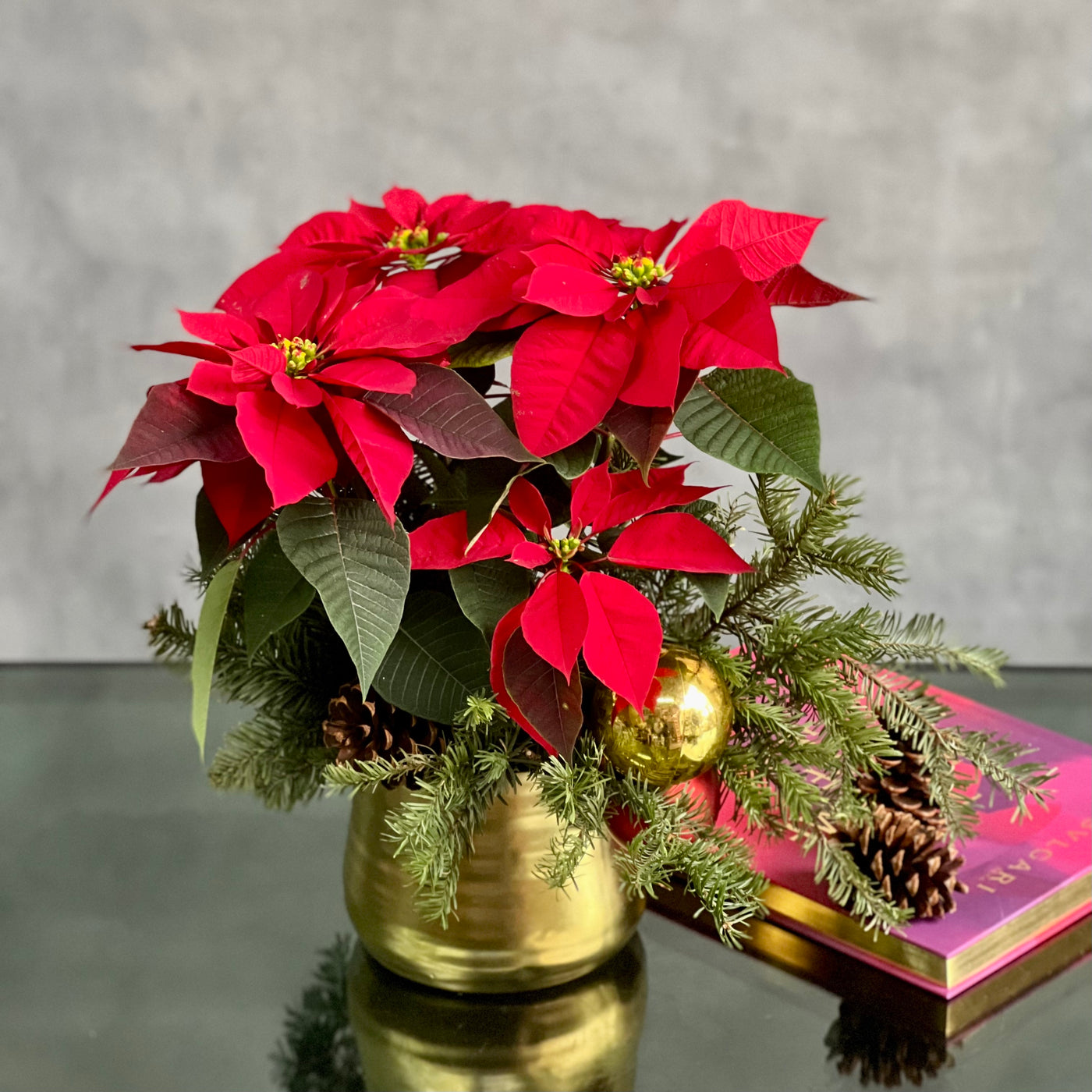 Christmas arrangement featuring poinsettias, holiday ornaments, seasonal greens, and pine cones in a gold pot, available for same-day delivery by Beverly Hills Florist.