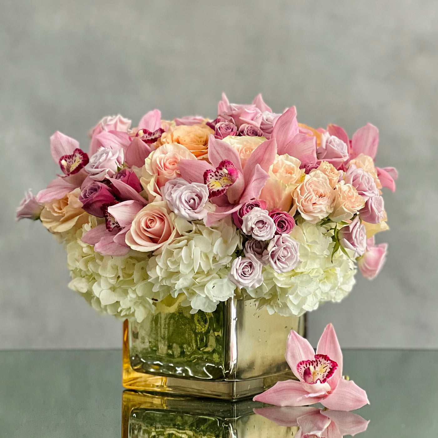 Elegant mixed bouquet of roses, orchids & hydrangeas in a mirrored gold vase