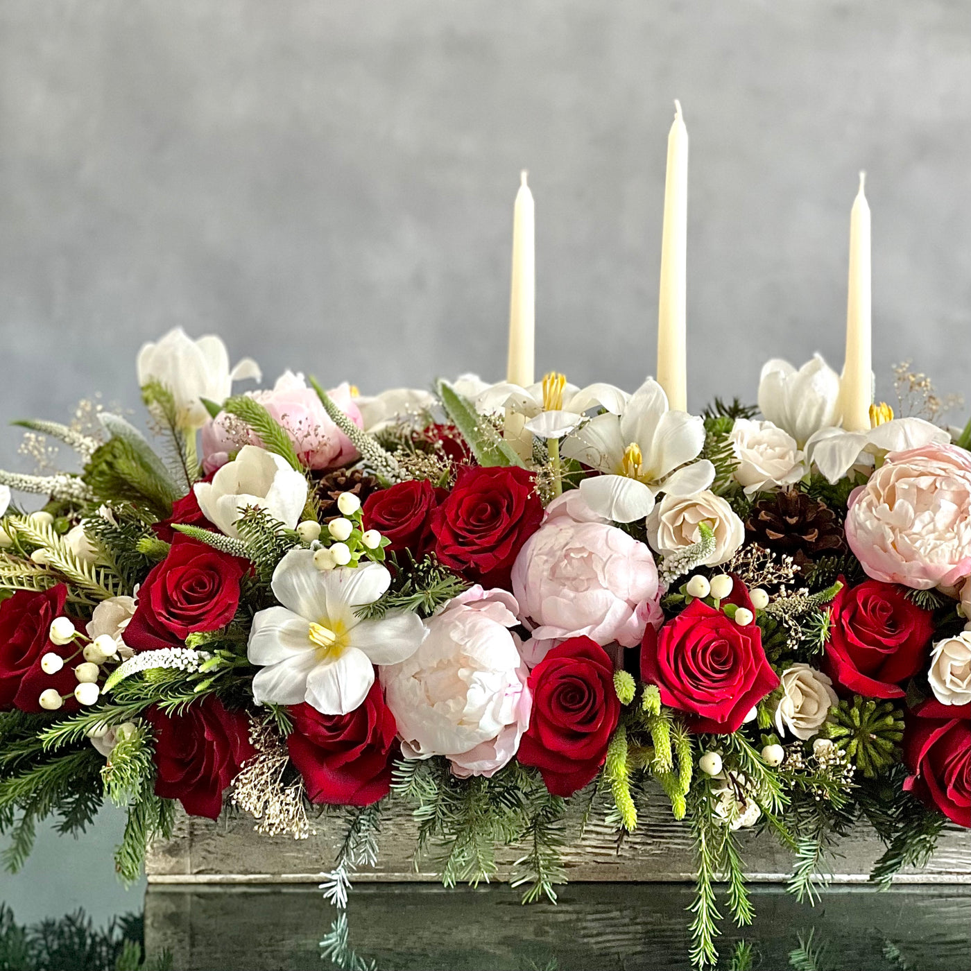 Elegant holiday centerpiece featuring red roses, white tulips, peonies, and berries in a chic arrangement for same-day delivery in Beverly Hills, CA.