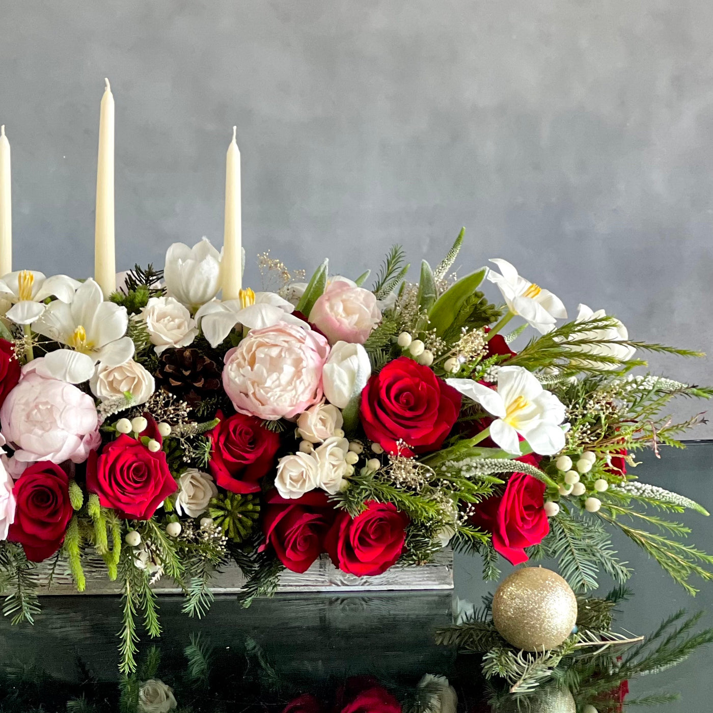 Elegant holiday centerpiece featuring red roses, white tulips, peonies, and berries in a chic arrangement for same-day delivery in Beverly Hills, CA.