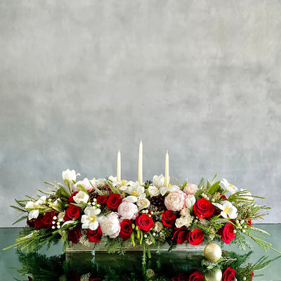 Elegant holiday centerpiece featuring red roses, white tulips, peonies, and berries in a chic arrangement for same-day delivery in Beverly Hills, CA.