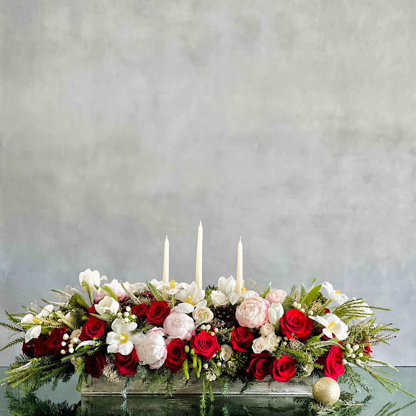 Elegant holiday centerpiece featuring red roses, white tulips, peonies, and berries in a chic arrangement for same-day delivery in Beverly Hills, CA.