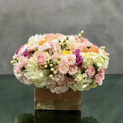 Pastel Perfection floral arrangement with soft pastel roses, Dutch hydrangeas, and seasonal flowers in a box base tied with a cream bow, available for same-day delivery