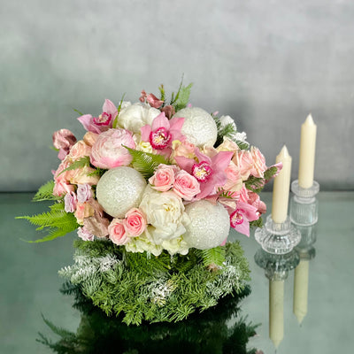 Pink Holiday arrangement featuring pink orchids, peonies, roses, and winter greens in a glass vase, available for same-day delivery by Beverly Hills Florist.