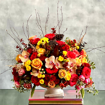 Brighten their day with this vibrant bouquet. This bouquet dashingly displays peach roses and garden roses, peach and pink orchids, yellow, red and spray roses, and pink dutch double tulips. A gorgeous mix of bold, rich and bright flowers is the best way to boost any mood and for any occasions! Overall 17x 12. 