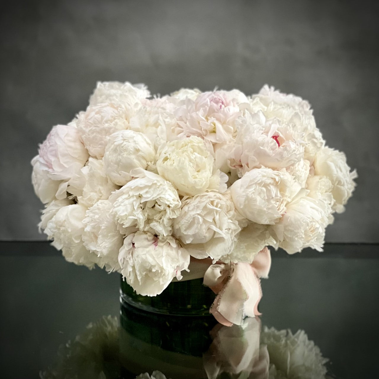 Peony Wonder presented by Beverly Hills Florist can also be made for same day delivery ! This over 50 white blush peony arrangement nested in a simple glass vase with a bow. Its beautiful in itself without any other floral. A beautiful sentiment for Birthdays, Welcome Homes, Thank you, Thinking of you and sympathies. 